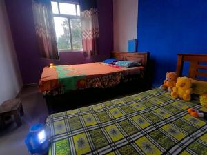 a bedroom with two beds and two teddy bears at Ice mango homestay Badulla in Badulla