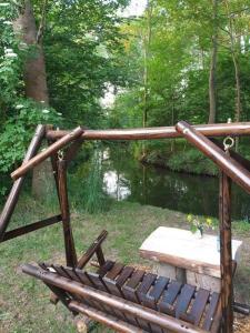 a wooden bench sitting in front of a pond at Ferienhäuser Harmonie I & II in Burg Kauper