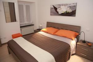 a bedroom with a large bed with orange pillows at Home Sweet Home in Lavagna