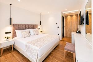 a bedroom with a large white bed and a chair at Nobile Boutique Hotel in Agios Gordios