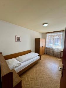 a bedroom with a bed in a room with a window at Hotel Goldenes Kreuz - since 1605 in Vipiteno