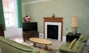 a living room with a couch and a fireplace at Collins House in Knaresborough