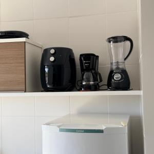 a shelf with a blender and other appliances on it at Veredas Do Rio Quente Flat Service 723 in Rio Quente