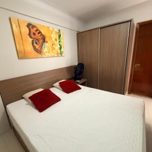 a bedroom with a bed with two red pillows on it at Veredas Do Rio Quente Flat Service 723 in Rio Quente +20 photos