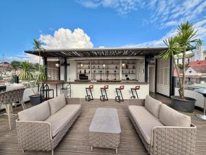 a patio with two couches and a bar on a deck at Grand Hotel Urban in Antananarivo