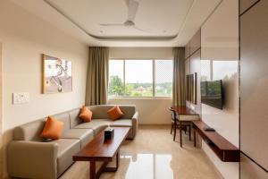 a living room with a couch and a table at Fortune Village Hotel in Kundapur