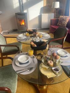 a glass table with dishes on it with a fireplace at Het Ambachtshuis Warffum in Warffum