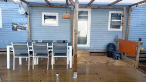 a table and chairs in front of a blue house at Beach Resort Kamperland - 765 in Kamperland