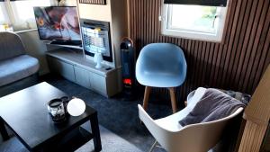 a living room with a chair and a television at Beach Resort Kamperland - 765 in Kamperland
