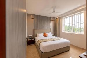 a bedroom with a bed and a window at Fortune Village Hotel in Kundapur