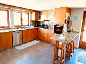 a kitchen with wooden cabinets and a marble counter top at Casa da Lage - Piscina privada - Vistas rio - "Gerês" in Geres