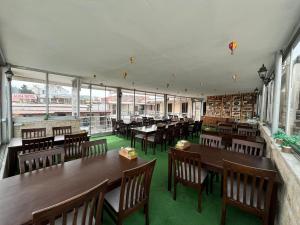 een restaurant met houten tafels en stoelen en ramen bij Alida Hotel Pamukkale in Pamukkale