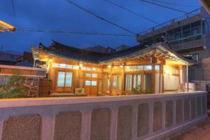 a house with a lit up facade with a fence at Guma Modern HanokStay in Daegu