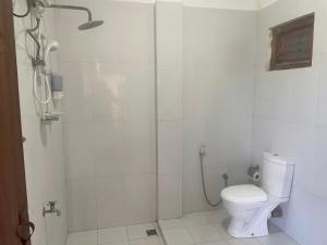 a white bathroom with a shower and a toilet at D & D Beach Resort in Trincomalee +37 photos