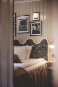 a bedroom with a bed with pictures on the wall at Badhotellet Villa Berg in Norrtälje