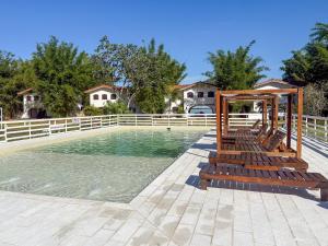 a swimming pool with benches in the water at Hueso cue 105 in Paso de la Patria