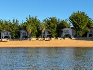 a sandy beach with houses in the background at Hueso cue 105 in Paso de la Patria