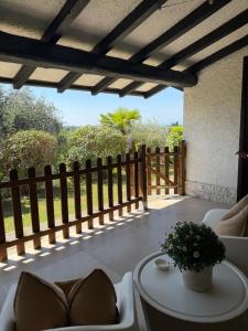 a patio with a fence and a table and chairs at Casa Jeyel in Lazise