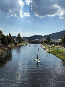 a man on a paddle board in a river at Casa Rural Picón con jardín y piscina privada in Ocero +28 photos
