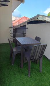 a wooden table and chairs on the grass at GLJ Apartment in Ormoc