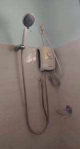 a shower in a bathroom with a blow dryer at GLJ Apartment in Ormoc +9 photos