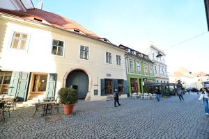 a group of people walking down a street with buildings at FLH - Hömvert in Sibiu