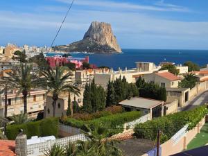 a view of a mountain in the ocean with buildings at Apartamentos El Tosal 7E in Calpe