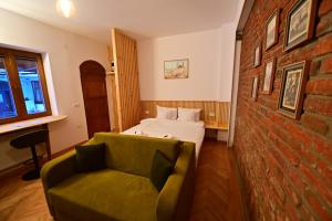 a room with a bed and a couch and a brick wall at FLH - Hömvert in Sibiu