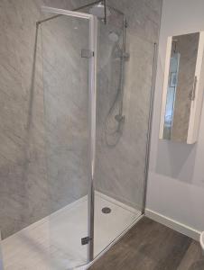 a shower with a glass door in a bathroom at Coastguard cafe room 2 in Hastings