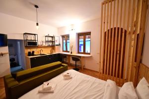 a living room with a bed and a kitchen at FLH - Hömvert in Sibiu