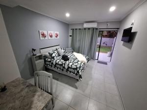 a bedroom with a bed and a table in it at Ivy Roots Guest House in Mokopane