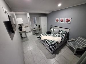 a bedroom with a bed and a bench in it at Ivy Roots Guest House in Mokopane +10 photos