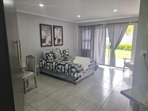 a bedroom with a bed and a large window at Ivy Roots Guest House in Mokopane