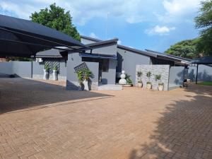 a building with a courtyard with potted plants at Ivy Roots Guest House in Mokopane