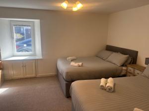 a bedroom with two beds and a window at Lower Mill Apartment in Newmilns