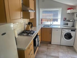 a kitchen with a washing machine and a washer at Lower Mill Apartment in Newmilns