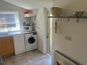 a kitchen with a washing machine and a sink at Lower Mill Apartment in Newmilns +3 photos