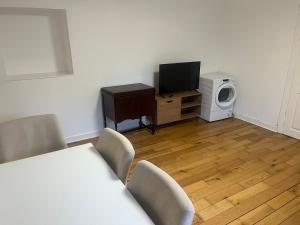 a living room with a television and a microwave at Lower Mill Apartment in Newmilns