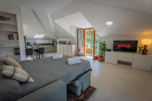 a living room with a large bed and a kitchen at Marble House Varenna Lake Como in Varenna