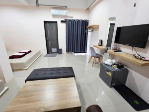 a large living room with a tv and a couch at Lynn Living (ลินน์ ลิฟวิ่ง) in Ban Non Muang