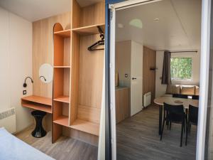 a small apartment with a dining room and a bedroom at Camping Terre d'Armor in Bourseul