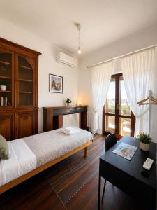 a bedroom with a bed and a desk and a window at B&B Colombo in Pisa