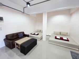 a living room with a couch and a table at Lynn Living (ลินน์ ลิฟวิ่ง) in Ban Non Muang