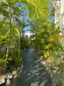 a path through a garden with palm trees at Tucan Resort & Spa in Paramaribo