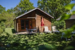 a cabin with a table and chairs in the yard at Camping Terre d'Armor in Bourseul