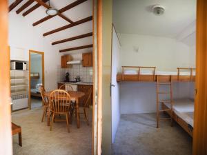 a room with a table and a kitchen with a bunk bed at Camping Terre d'Armor in Bourseul