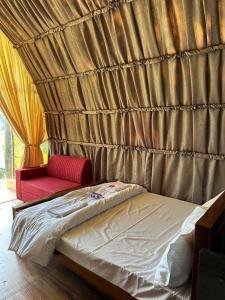 a bedroom with a bed and a red couch at Riva farmstay in Mayyanād +12 photos