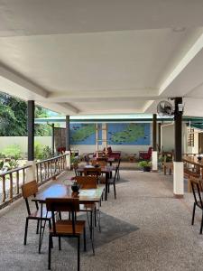 a restaurant with tables and chairs and a living room at Midnite Inn in Panglao Island
