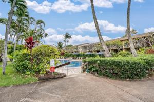 a resort with a swimming pool and palm trees at Napili Shores E240 in Kahana