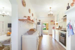 a kitchen with white walls and wooden floors at Celestial Melides Country House in Melides
